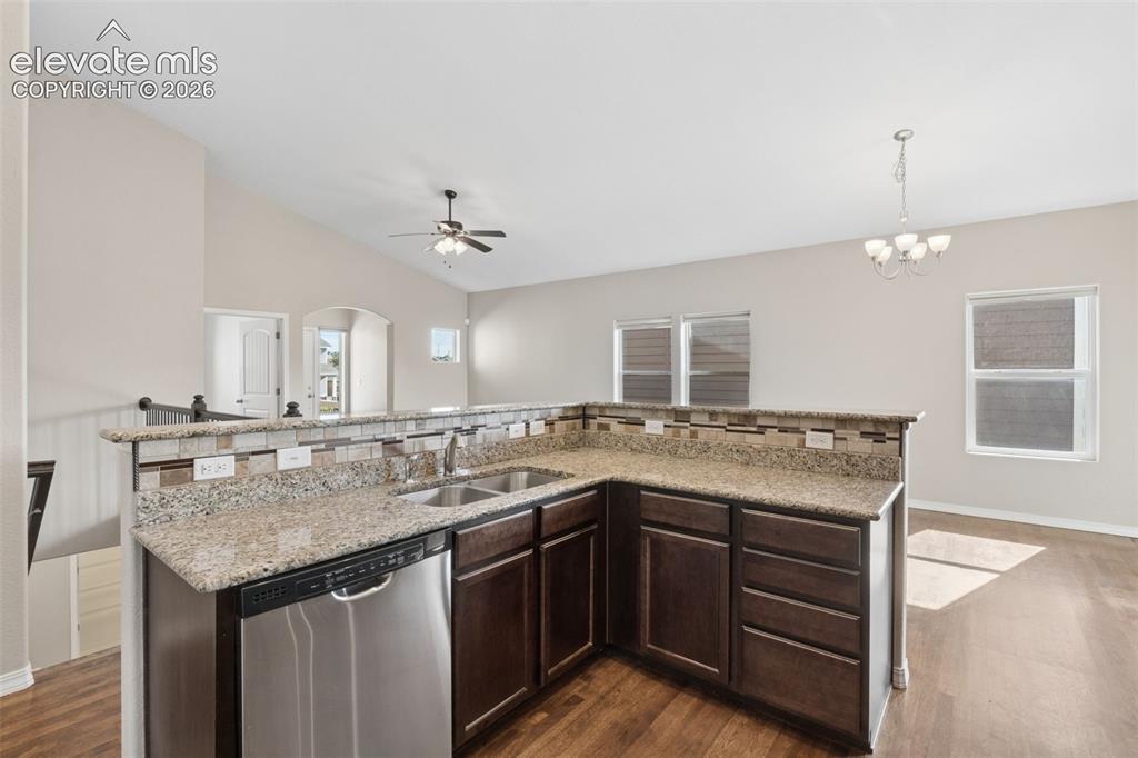Image 12 of 46: Kitchen featuring an L-shaped peninsula with granite-finish countertops, st