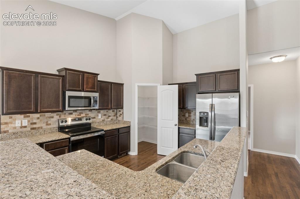 Image 13 of 46: Kitchen featuring a breakfast bar with dual basin stainless steel sink, dar
