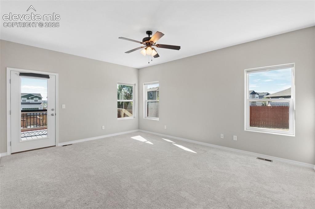 Image 17 of 46: Spacious interior room featuring light gray walls and plush gray carpeting
