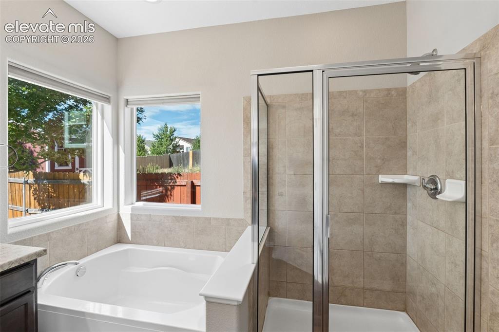 Image 22 of 46: Spacious bathroom featuring a built-in soaking tub with surrounding windows