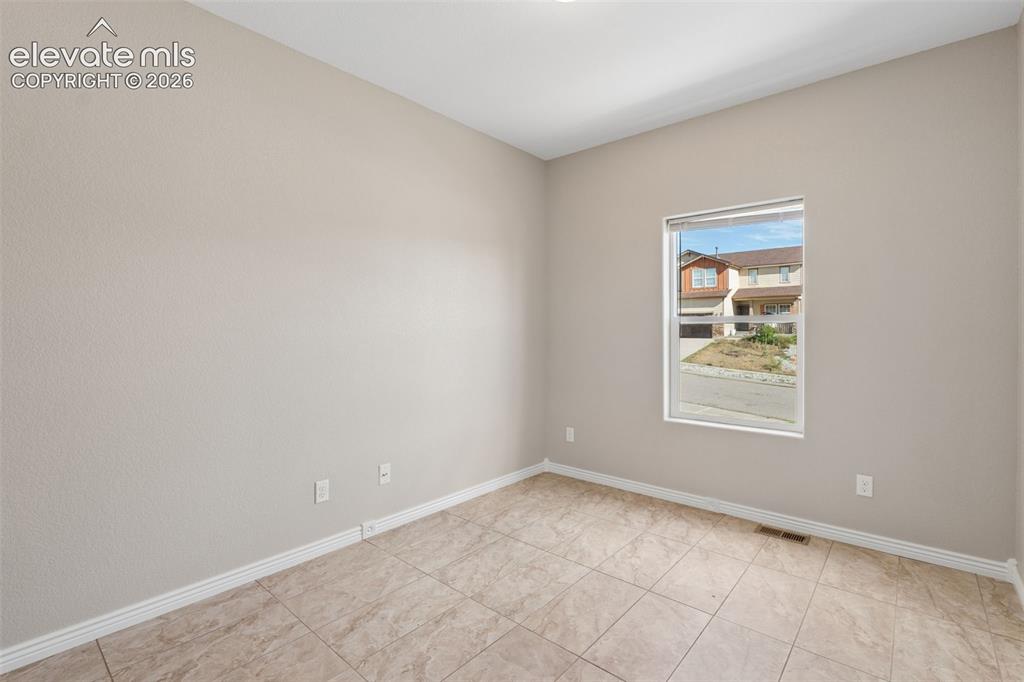 Image 24 of 46: Interior room featuring neutral wall color, white trim, and tiled flooring