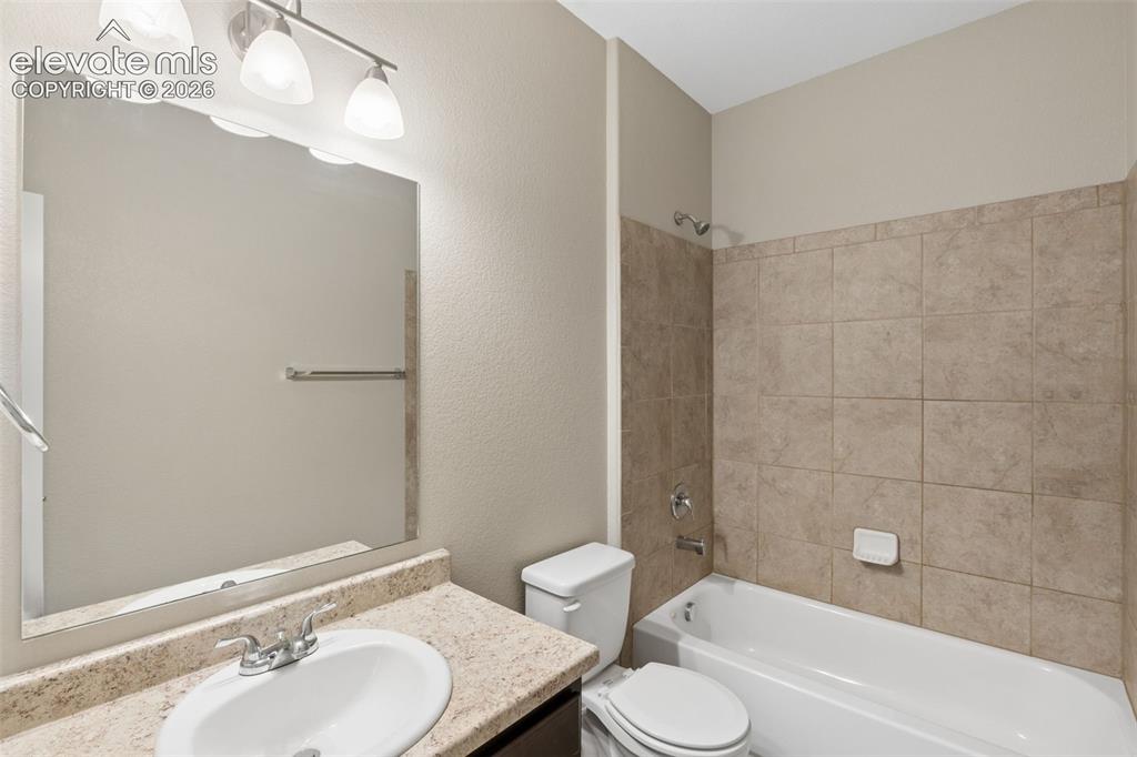 Image 25 of 46: Main Level Bathroom featuring a vanity with a speckled countertop, integrat