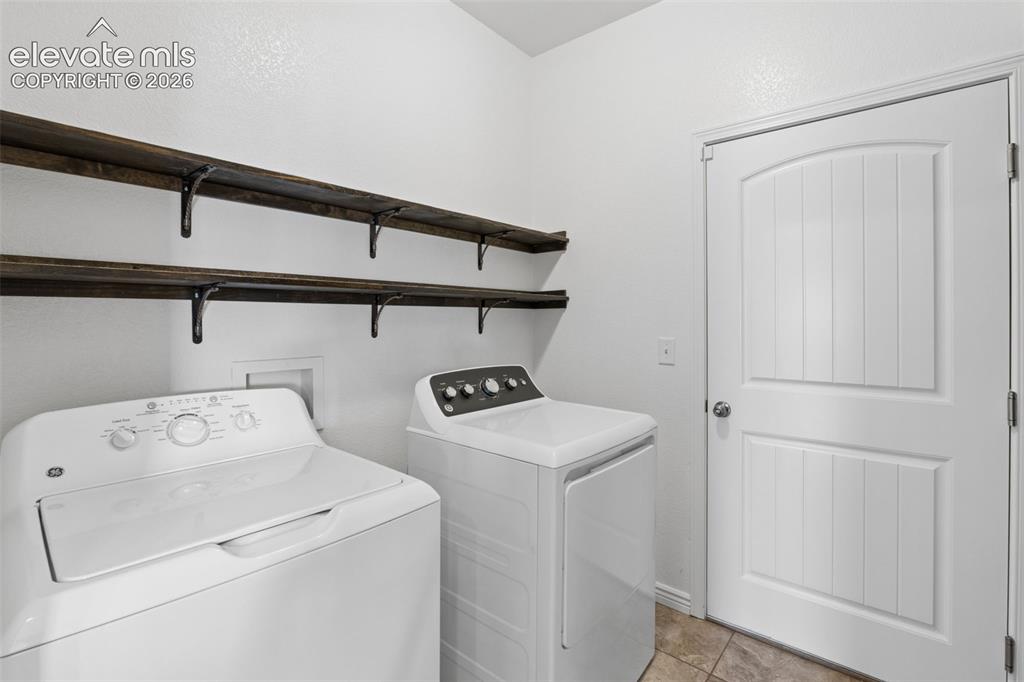 Image 41 of 46: Dedicated laundry area featuring a white paneled door, two dark wood-finish