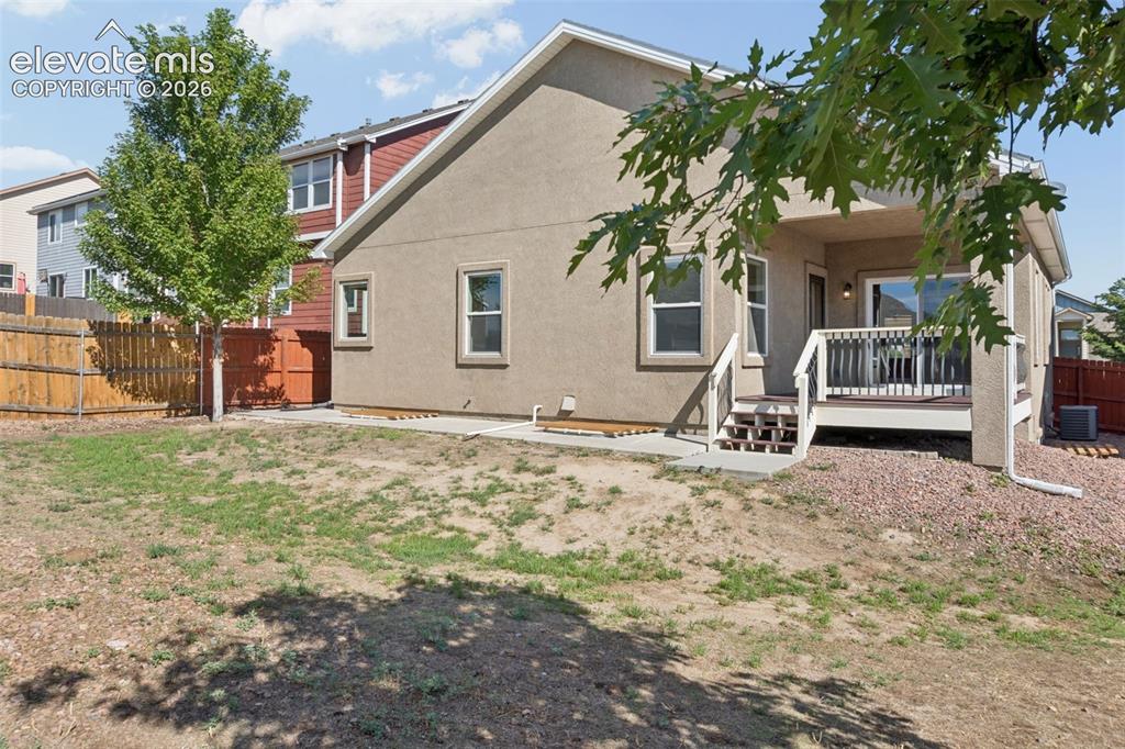 Image 44 of 46: Rear exterior featuring a covered deck, sliding glass door, and stucco sidi