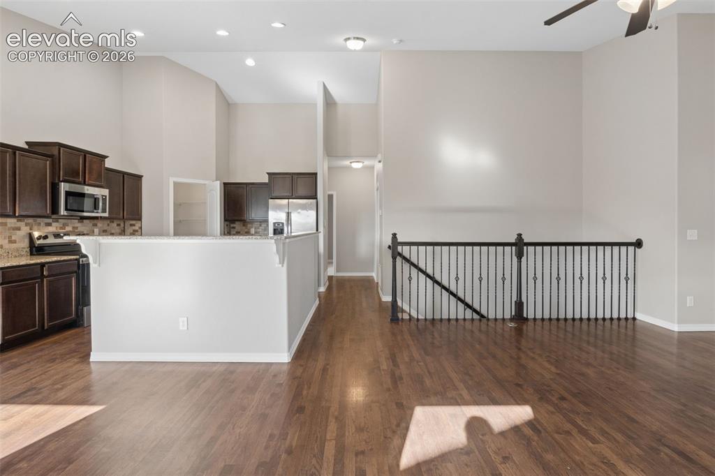 Image 7 of 46: Open-concept living space featuring wood-finish flooring, a kitchen with da