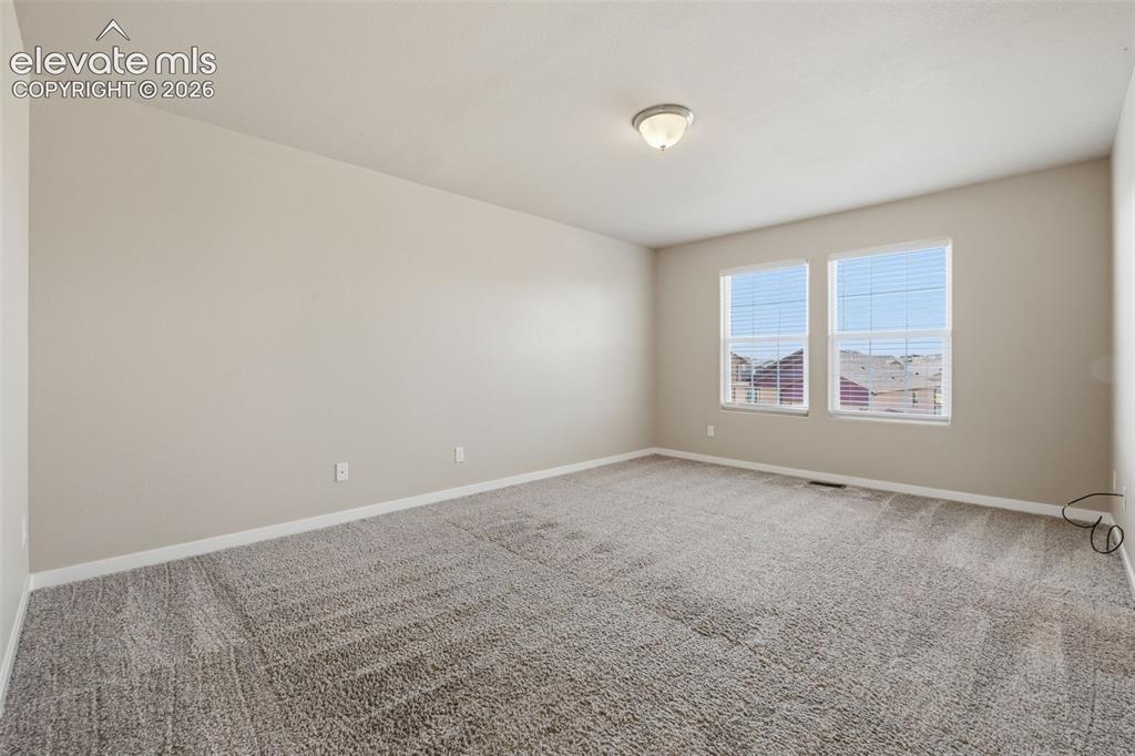 Image 27 of 34: A third secondary bedroom upstairs adds flexibility for family, guests or a