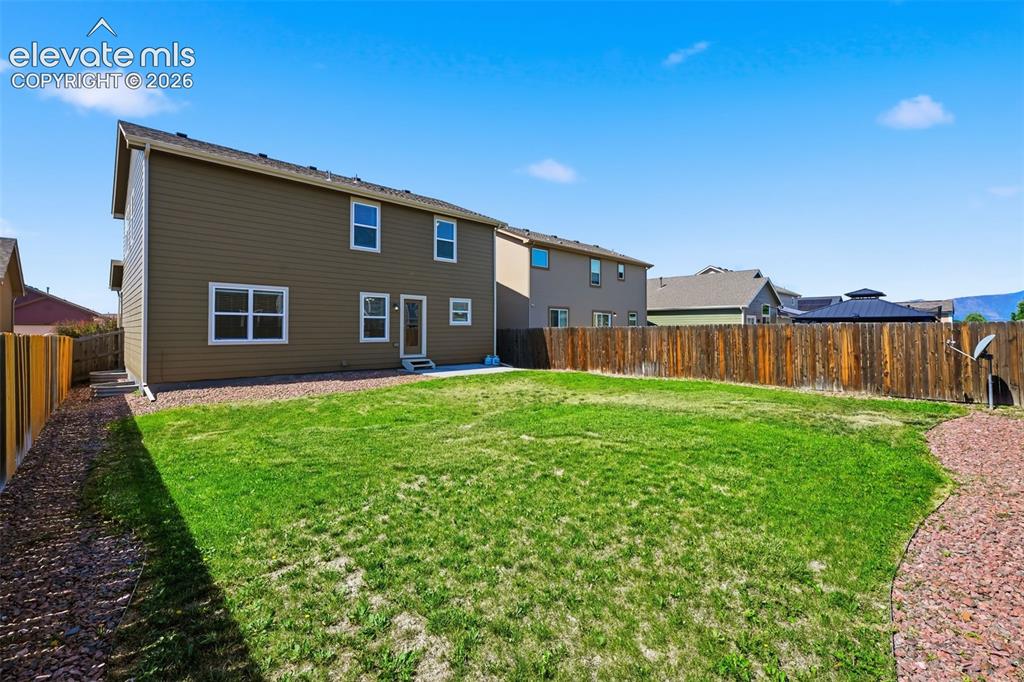 Image 40 of 43: Wide backyard view shows the generous outdoor space and full rear elevation