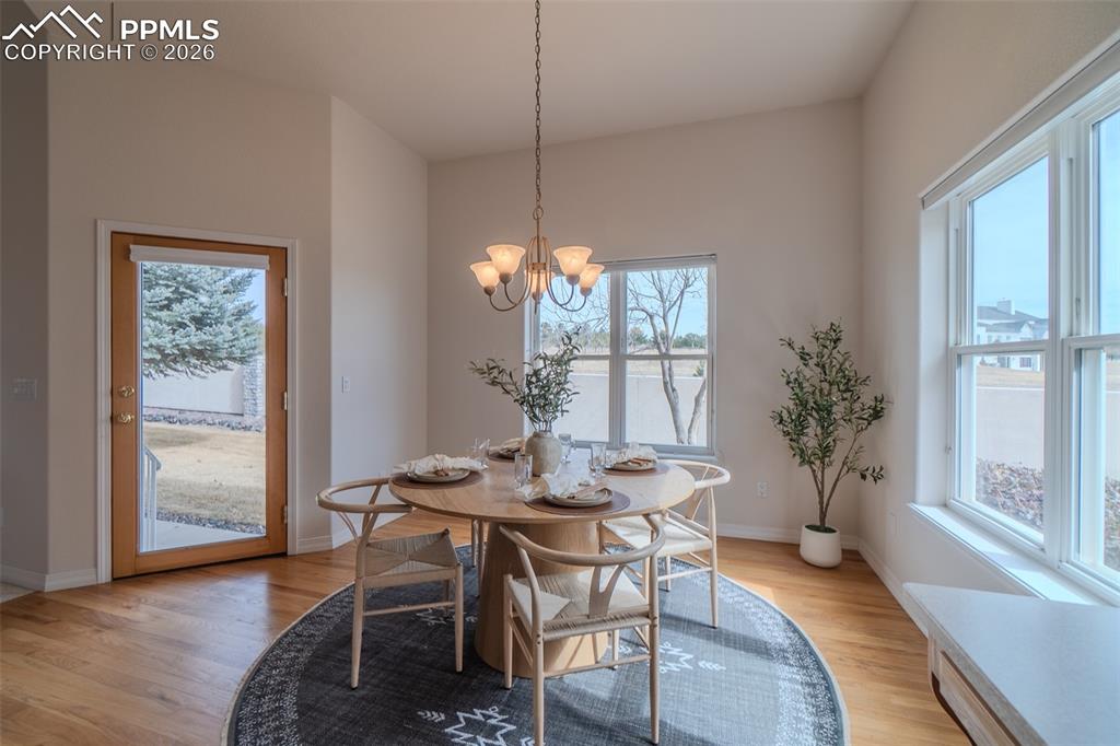 Image 12 of 50: Dining area with light wood-type flooring and hanging lights