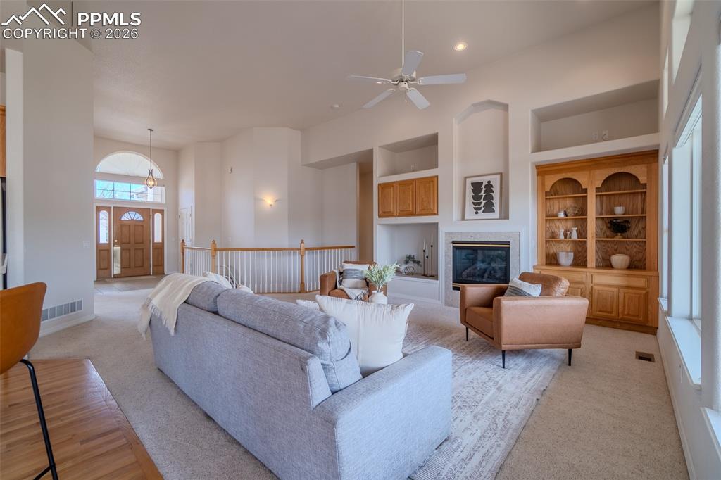 Image 15 of 50: Living area featuring built in features, a ceiling fan, light colored carpe