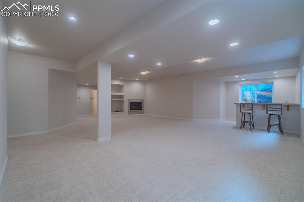 Image 30 of 50: Finished below grade area with light colored carpet, recessed lighting, a f