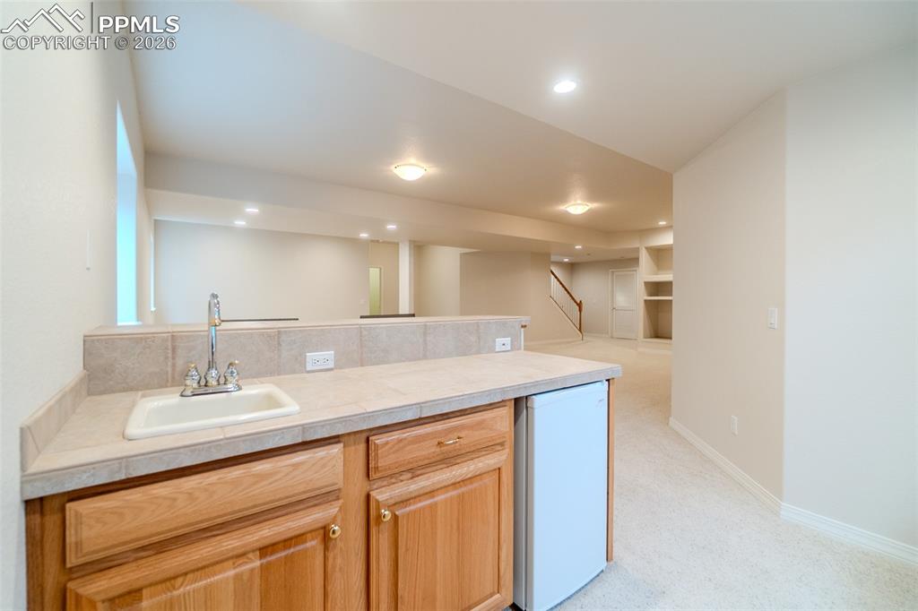 Image 35 of 50: Kitchenette with a peninsula, light colored carpet, recessed lighting, and 