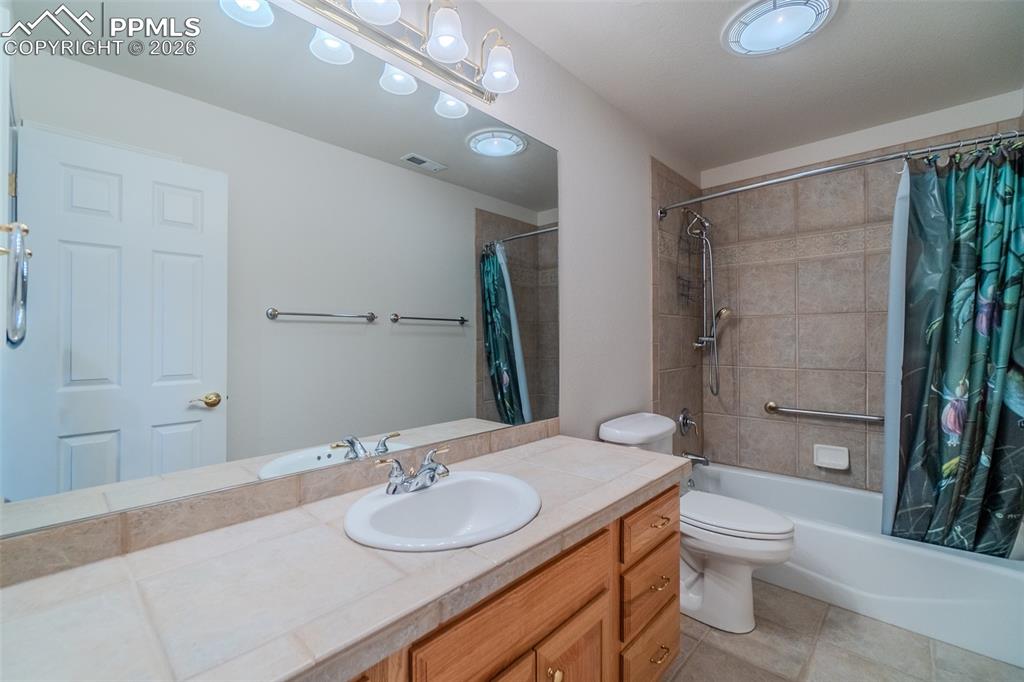 Image 37 of 50: Full bath with vanity, shower / tub combo with curtain, and light tile patt