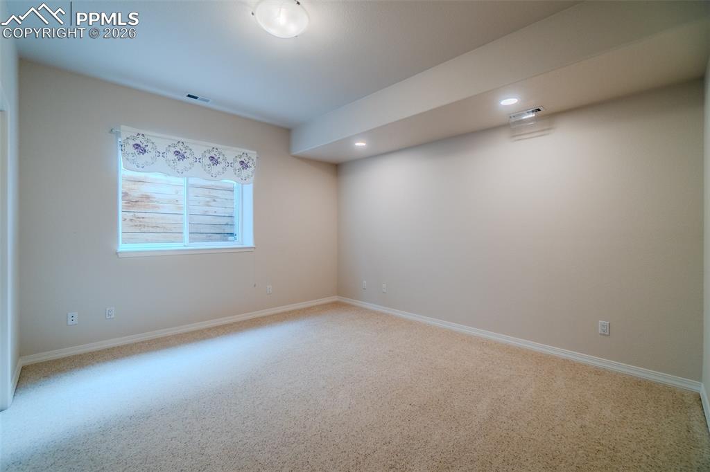 Image 38 of 50: Bedroom in basement carpet and recessed lighting