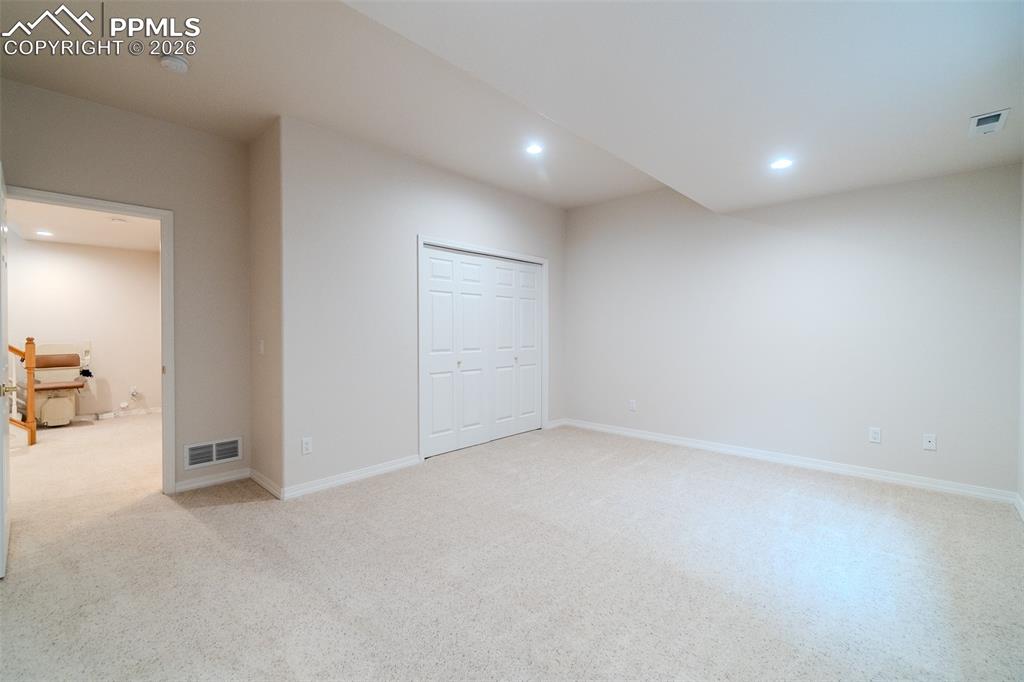 Image 41 of 50: Bedroom in basement featuring light carpet, recessed lighting, and a closet