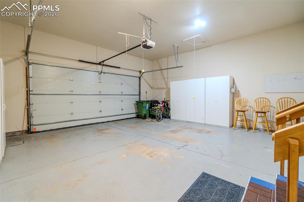 Image 45 of 50: Garage featuring a garage door opener