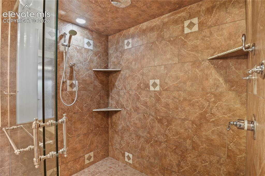 Image 15 of 50: Oversized walk-in shower with a frameless European glass enclosure & multip
