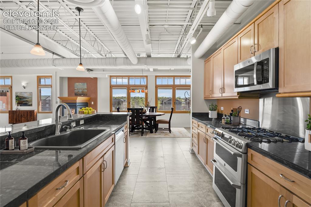 Image 6 of 50: Granite countertops, a generous eating bar, stainless steel appliances incl