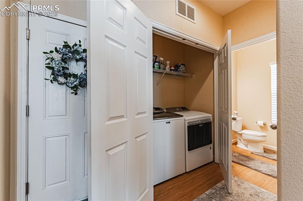 Image 11 of 27: Laundry room featuring independent washer and dryer and wood-type flooring