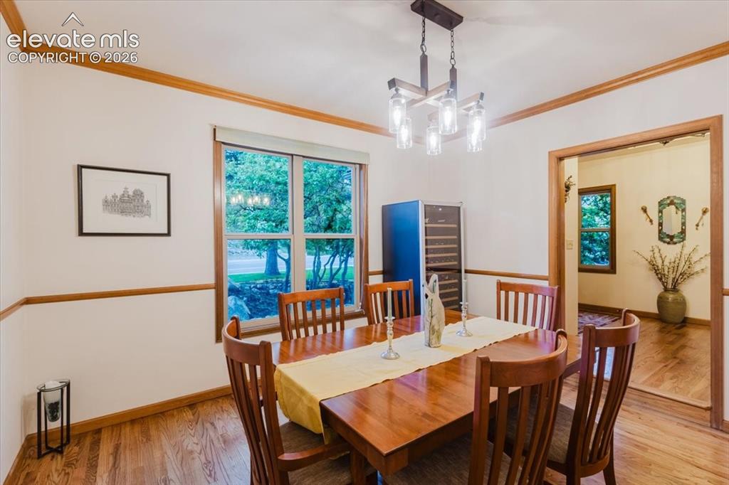 Image 10 of 50: Dining area with hard wood flooring, a contemporary chandelier, and a large