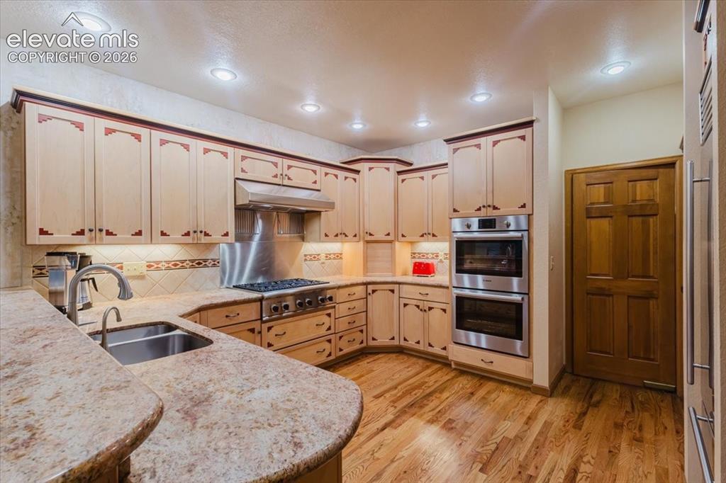Image 12 of 50: Kitchen featuring hard wood flooring, recessed lighting, double basin sink,
