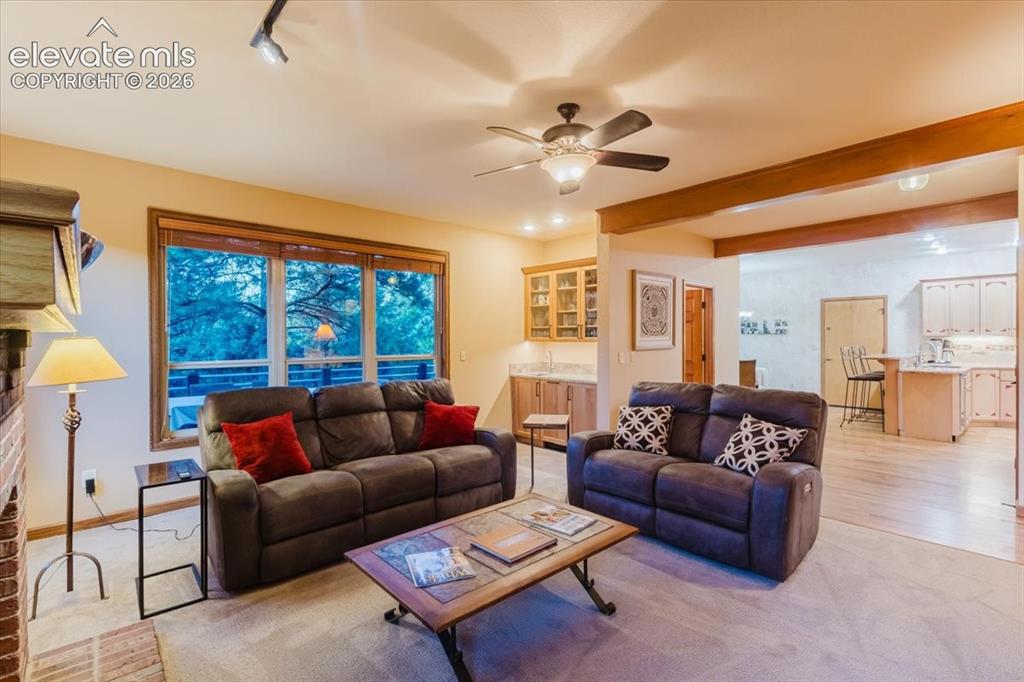 Image 18 of 50: Spacious living area featuring a large window, a ceiling fan, and track lig
