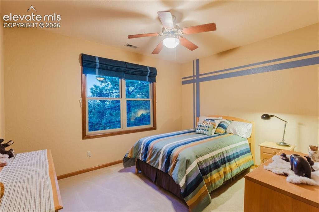 Image 28 of 50: Window with wood-finish trim, a ceiling fan with integrated lighting, and l