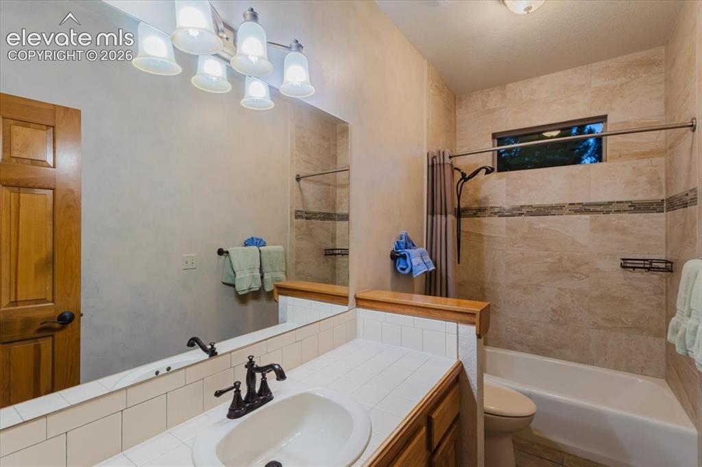 Image 30 of 50: Bathroom with a single vanity, white ceramic tile countertop, oil-rubbed br