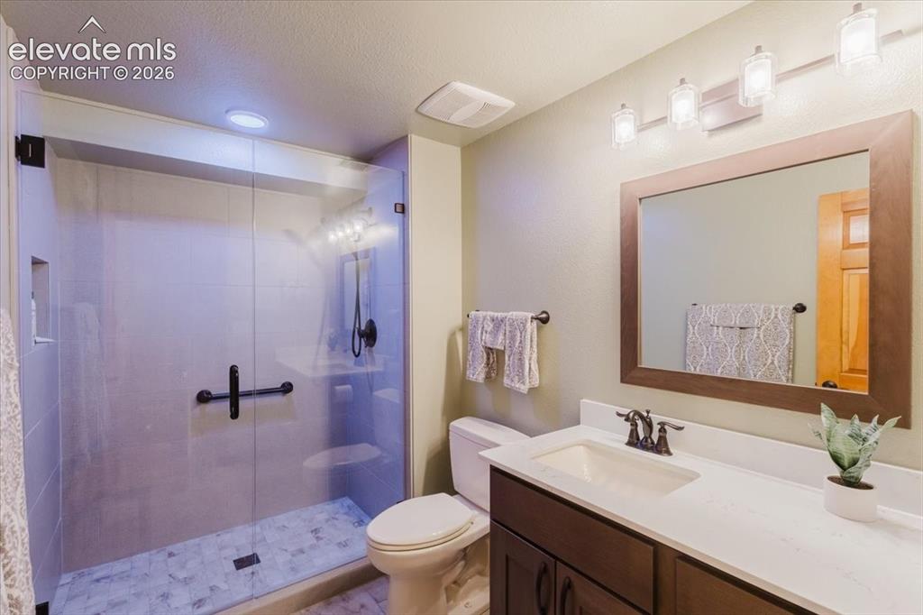 Image 35 of 50: Contemporary bathroom featuring a spacious glass-enclosed shower, a large v