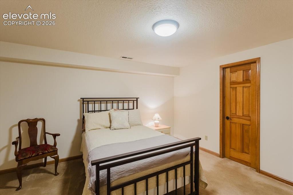 Image 36 of 50: Light-colored carpeted flooring extends throughout this room, featuring lig