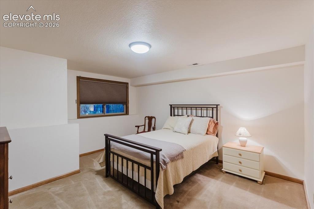 Image 37 of 50: Carpeted room featuring a window with a brown blind, white walls, and a cei