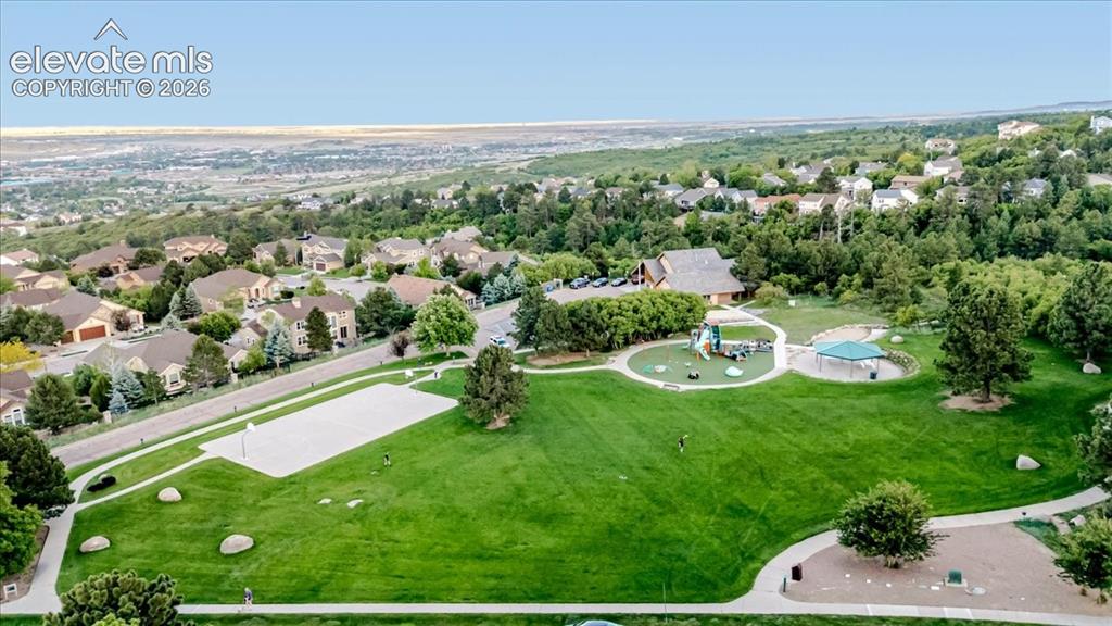 Image 42 of 50: Expansive community park featuring a large green space, paved walking paths