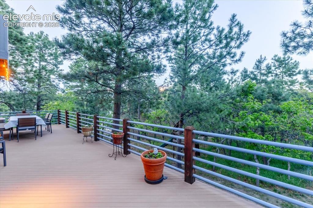 Image 46 of 50: Expansive outdoor deck featuring wood-finish flooring, a metal and wood rai