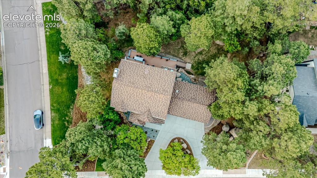 Image 5 of 50: Stone coated steel roof with a broad, curved concrete driveway