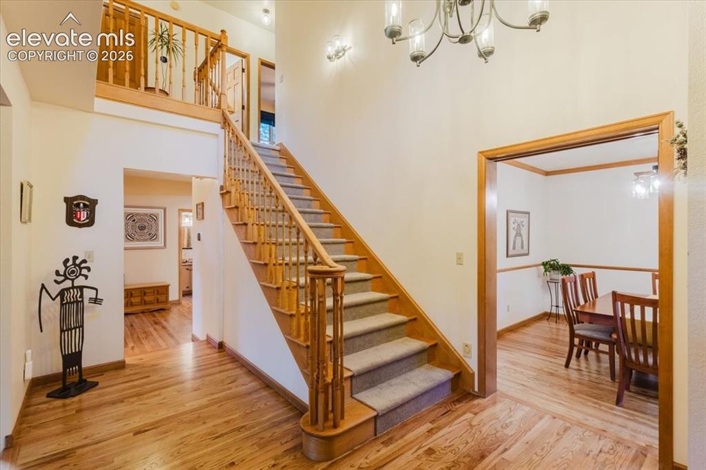 Image 6 of 50: Foyer featuring hard wood flooring, a grand staircase with wood banister an