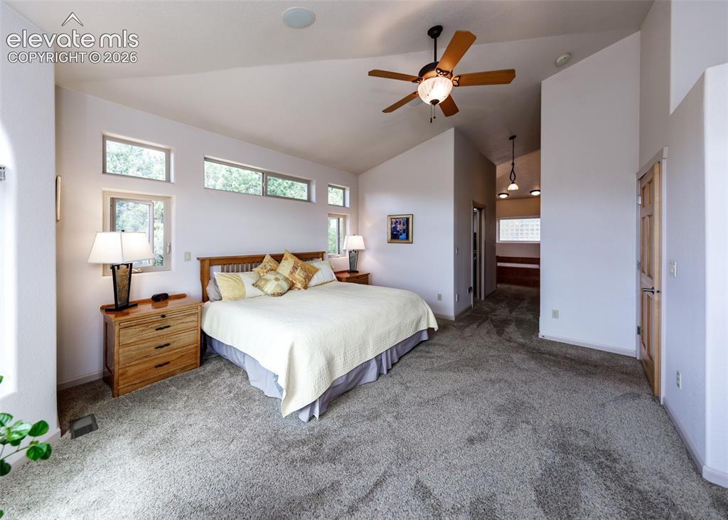 Image 11 of 50: Vaulted ceiling with a ceiling fan light fixture, high transom windows, gra