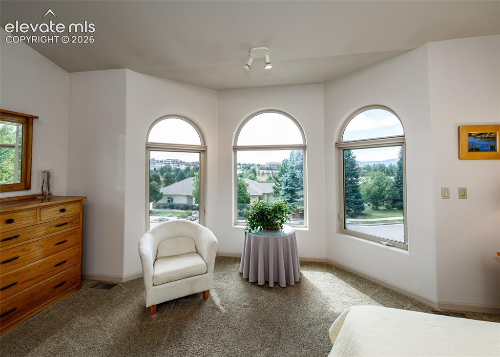 Image 12 of 50: Very bright primary with sitting area and walk-in closet.