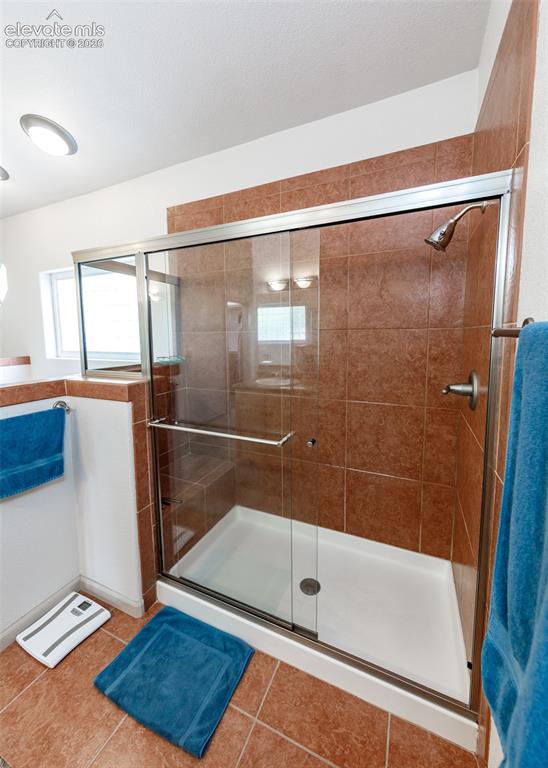 Image 15 of 50: Shower enclosure with a clear glass door, a bright white shower pan, and a
