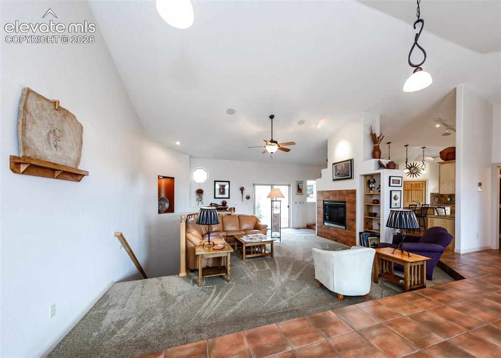 Image 17 of 50: Open-concept living area featuring soaring vaulted ceilings, step down, and