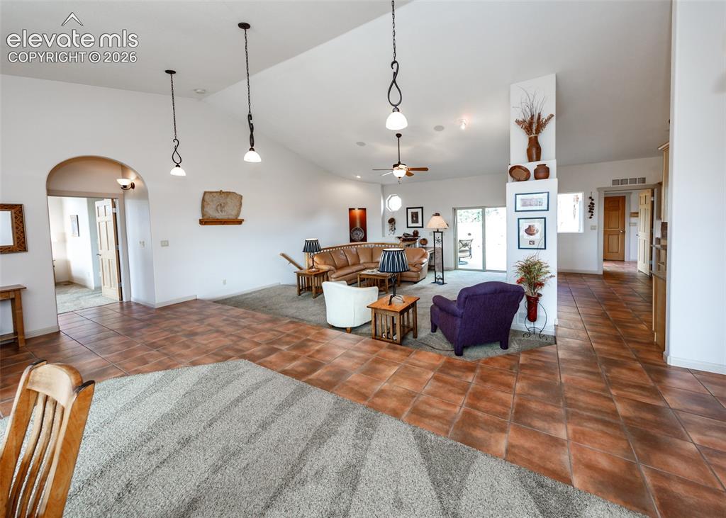 Image 19 of 50: Vaulted ceilings with recessed lighting, tile flooring, arched doorways, an