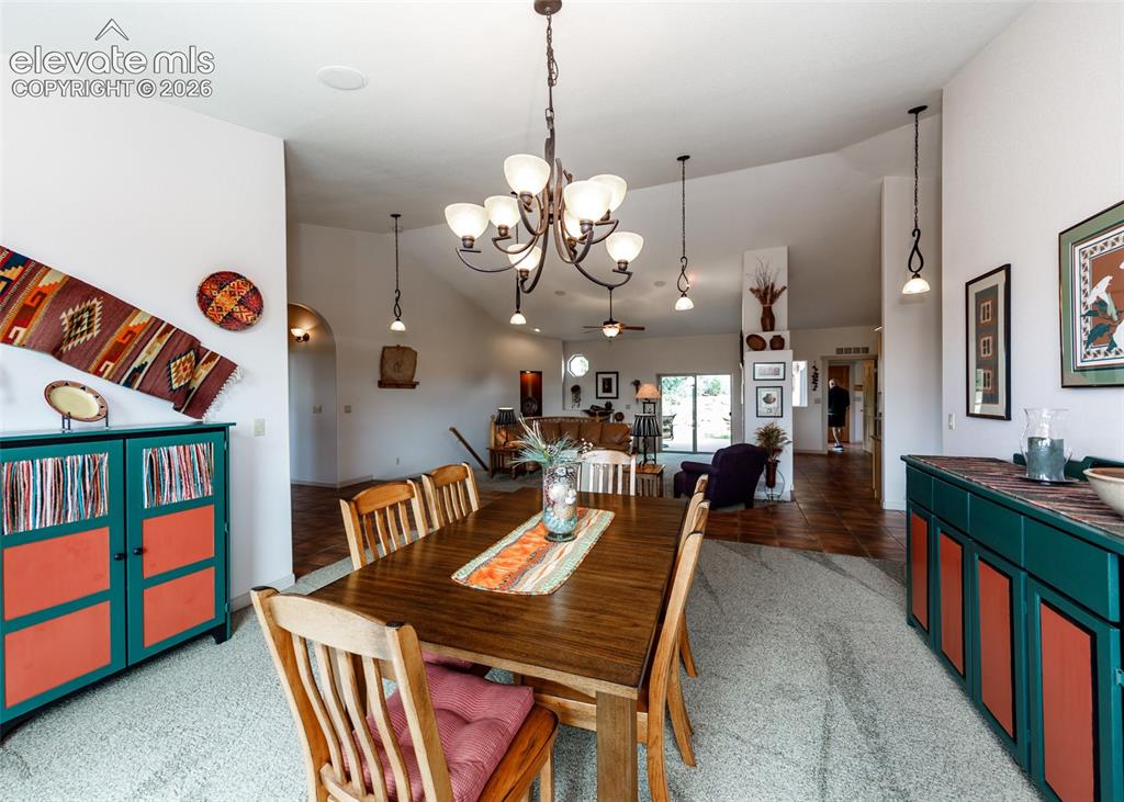 Image 23 of 50: Dining area featuring a chandelier, vaulted ceiling, recessed lighting, and