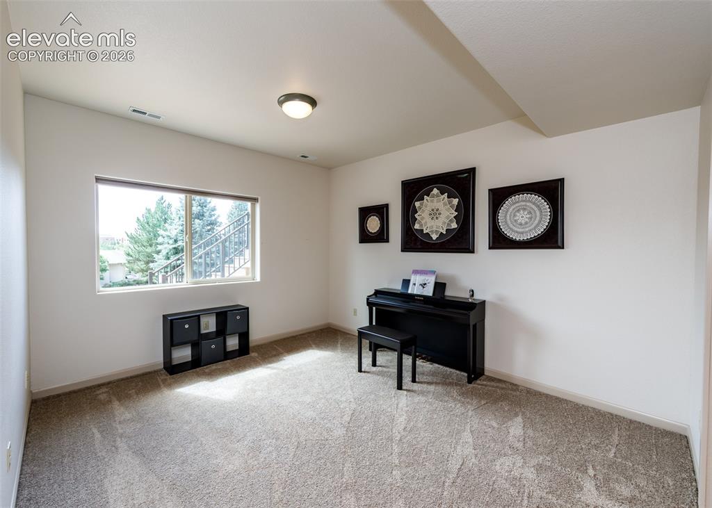 Image 24 of 43: Carpeted room with a large window and overhead lighting