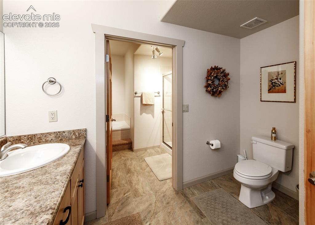 Image 31 of 50: Lower level 5-piece bathroom featuring double vanity and beautiful tiled fl