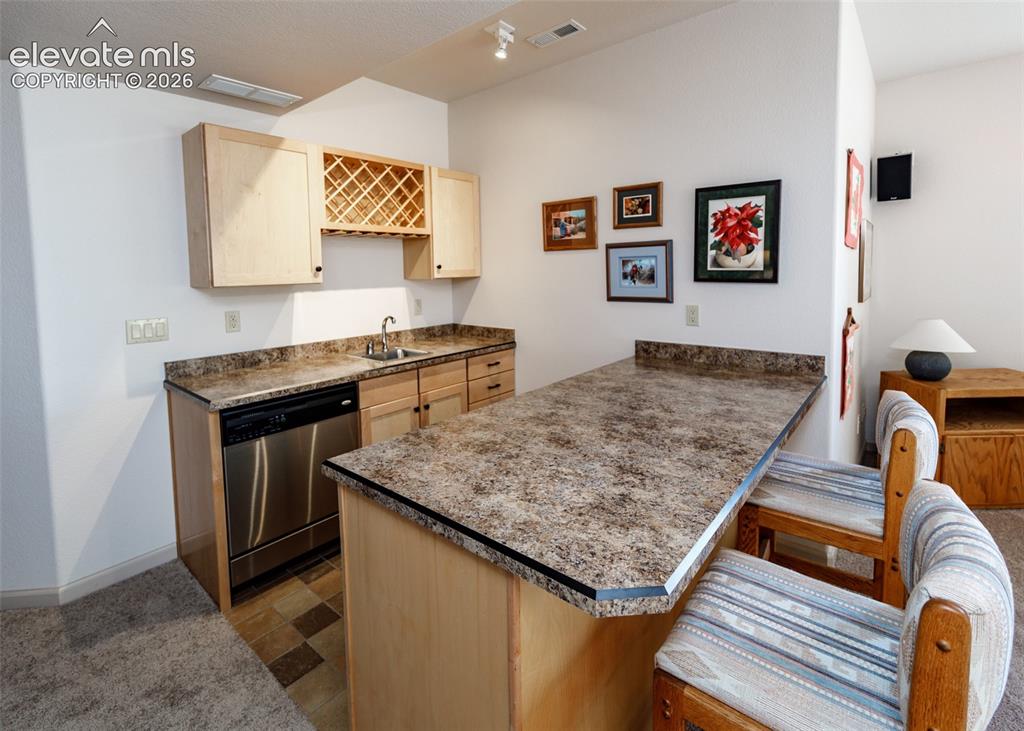 Image 37 of 50: Built-in wet bar also features a stainless steel dishwasher, plenty of stor