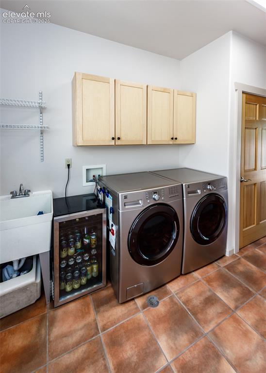 Image 42 of 50: Main level laundry with built-in cabinets, sink, built-in ironing board, an