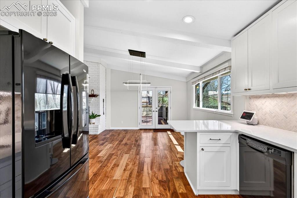 Image 11 of 48: Kitchen with black appliances, white cabinets, dark wood-type flooring, fre