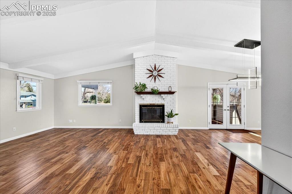 Image 15 of 48: Unfurnished living room featuring dark wood-style floors, a fireplace, and 