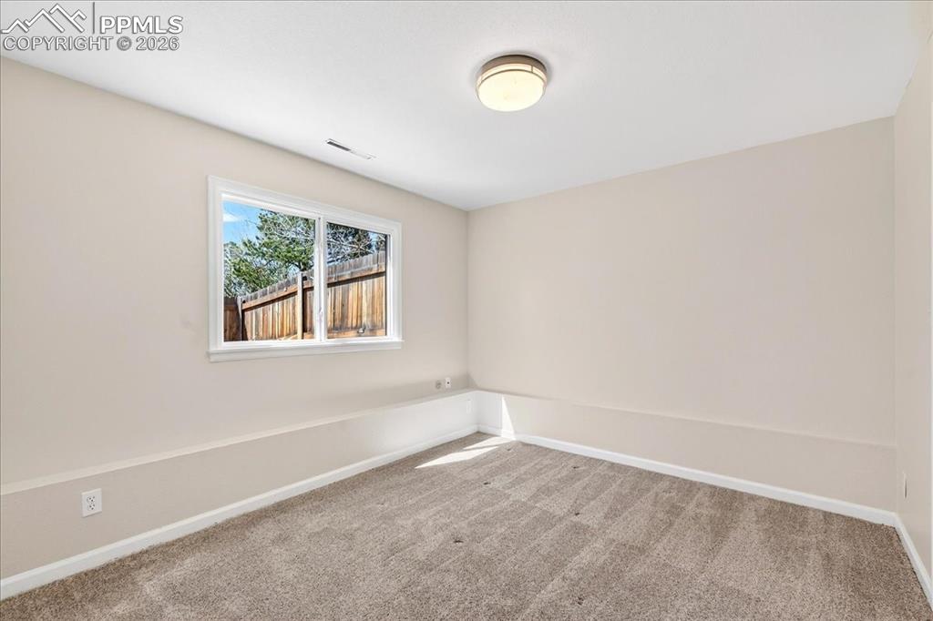 Image 24 of 48: Spare room with baseboards and light carpet