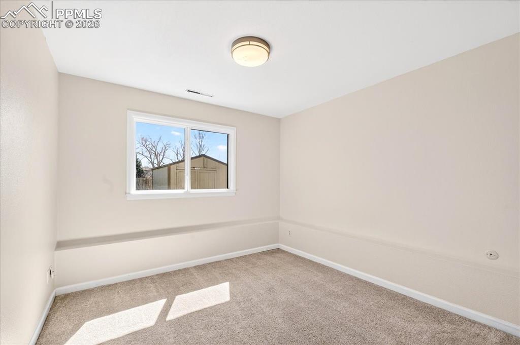 Image 27 of 48: Spare room featuring baseboards and light carpet