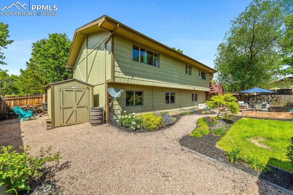 Image 37 of 48: Rear view of property with a fenced backyard, a shed, and a patio area