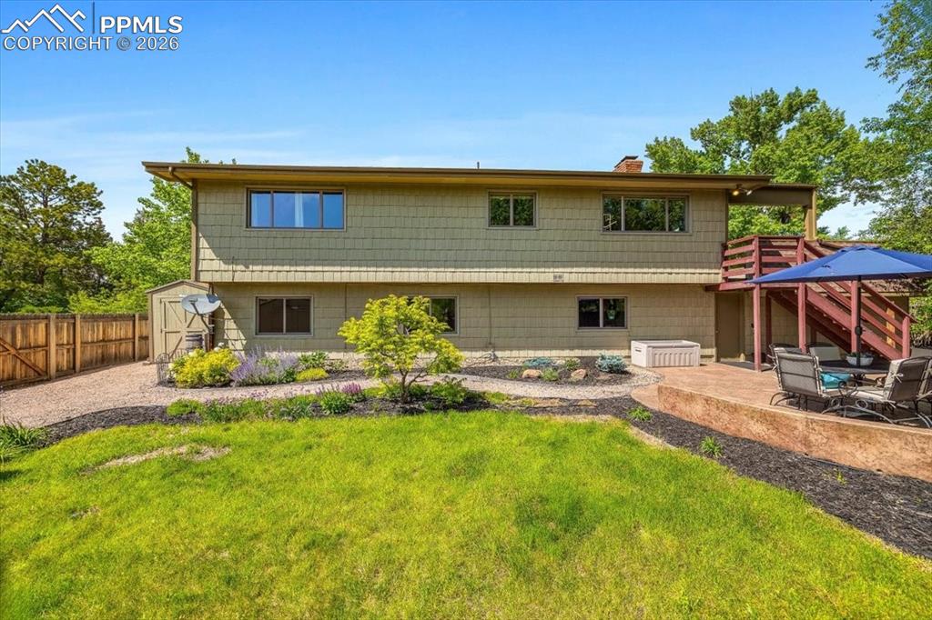 Image 39 of 48: Back of house featuring a shed, a patio, a chimney, and a fenced backyard